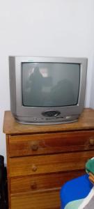 a television sitting on top of a wooden dresser at José Coro in La Serena