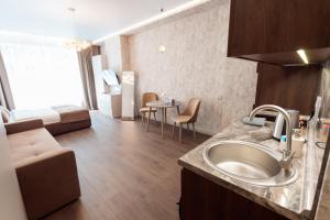 a kitchen with a sink and a living room at barasport city apartments in Kyiv +288 photos