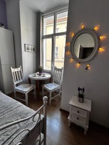 a bedroom with a bed and a mirror and a table at Prowansalski Sen - pokój z łazienką nr 3 in Poznań