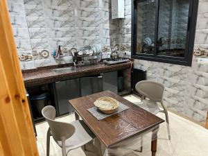 a kitchen with a table and a counter with a sink at Catrass Oualidia Apartments in Oualidia
