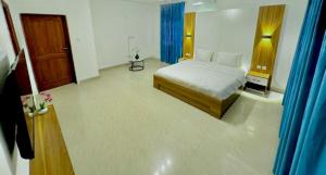 a bedroom with a bed and a room with a door at Résidence La Rose des Vents in Cotonou