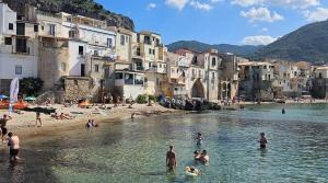 a group of people in the water at a beach at Vanity Suite in Cefalù