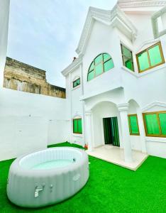 a house with a large tub in the yard at Résidence La Rose des Vents in Cotonou