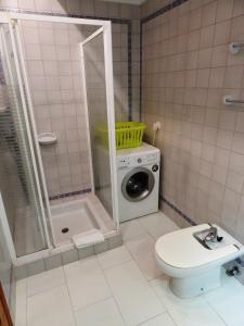 a bathroom with a washing machine and a toilet at Casita Viveca in Orba