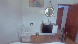 a bathroom with a toilet and a sink and a mirror at Résidence La Rose des Vents in Cotonou +33 photos