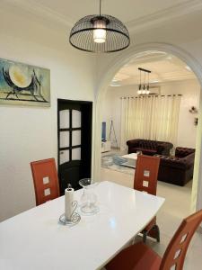 a dining room with a table and a living room at Résidence La Rose des Vents in Cotonou