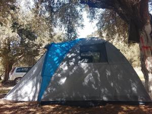 a tent sitting in the shade of a tree at Camping Shpella e Pirateve in Lukovë