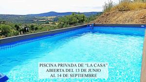 a swimming pool with a sign in front of it at NidoGredos Cabañas Ecológicas de Diseño in El Tiemblo +9 photos