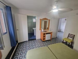 a bedroom with a bed and a desk and a mirror at Hostal Maxorata in Morro del Jable
