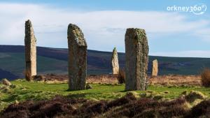 a group of stone pillars in a field with mountains in the background at Orkney Bed & Whisky in Orphir