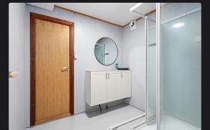 a bathroom with a wooden door and a mirror at U Maxa , całe mieszkanie na wyłączność in Sogndal