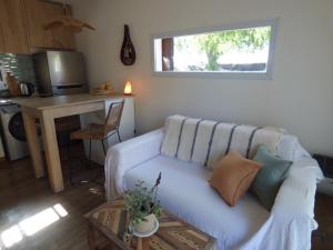 a living room with a white couch and a table at Almahue in Quebrada de los Pozos