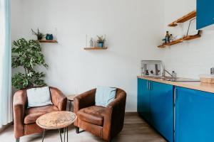 two chairs and a table in a kitchen with blue cabinets at Appartement - Michelet in Le Havre