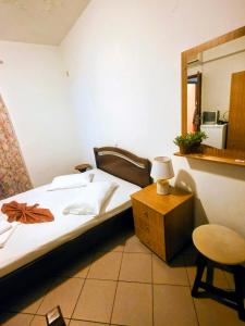 a bedroom with a bed and a table and a mirror at Pansion Panorama in Skala Marion