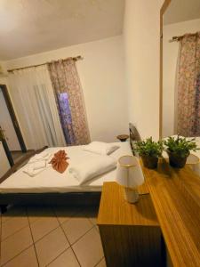 a bedroom with a bed and a table with a lamp at Pansion Panorama in Skala Marion +13 photos