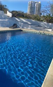 a swimming pool with blue water in front of a building at Bungalows El Mirador in Cruz de Huanacaxtle +6 photos