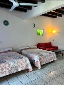a room with two beds and a couch in it at Bungalows El Mirador in Cruz de Huanacaxtle