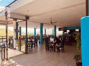 a person sitting at a table in a restaurant at Bungalows El Mirador in Cruz de Huanacaxtle