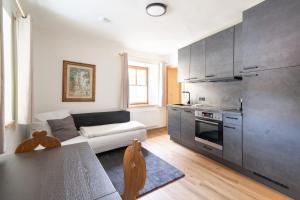 a living room with a couch and a kitchen at Resi´s Stadthaus in Kitzbühel +40 photos