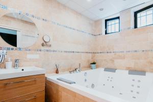 a bathroom with a tub and a sink and a mirror at Appartement - Michelet in Le Havre