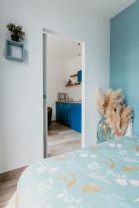 a bedroom with a bed with a blue and gold bedspread at Appartement - Michelet in Le Havre