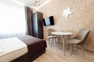 a hotel room with a bed and a table and chairs at barasport city apartments in Kyiv