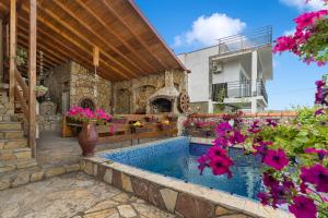a house with a swimming pool and flowers at Apartments by Proshevi in Star Dojran