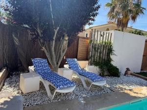 two blue and white chairs sitting next to a fence at Villa Mares Puig in Llucmajor