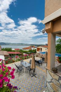a patio with tables and chairs and a view of the water at Apartments by Proshevi in Star Dojran