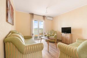 a living room with two chairs and a television at Apartments by Proshevi in Star Dojran