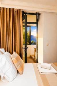 a bedroom with a white bed with a window at Luxury Sea Residence by Kristina in Tivat