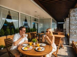 a man and woman sitting at a table drinking coffee at Hotel Lavenir in Biei