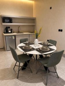 a dining room table with chairs and a kitchen at ملاذ 1 in Riyadh