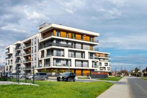 a large white building with cars parked in front of it at Apartament Janka in Zator