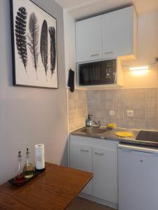 a kitchen with a sink and a microwave at Studio centre ville in Évreux +4 photos