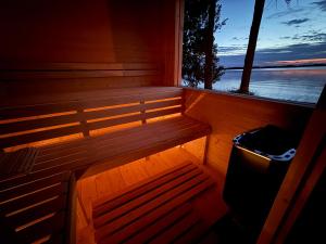 a sauna with a bench in front of a window at Mazurski Widok 2 in SzczybaÅ‚y OrÅ‚owskie +1 photo