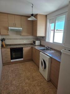 a kitchen with a washer and a sink and a dishwasher at Durino apartment with terrace in Moncófar +5 photos