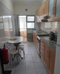 a kitchen with a table and a table and chairs at Gaivota Erudita in Buarcos