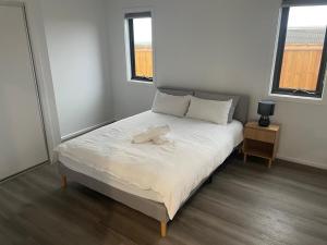 a bed in a room with two windows at Darley Retreat in Darley
