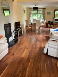 a living room with wood floors and a table and chairs at Clifden townhouse in Clifden