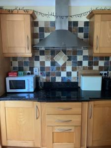 a kitchen with a stove and a microwave at Clifden townhouse in Clifden