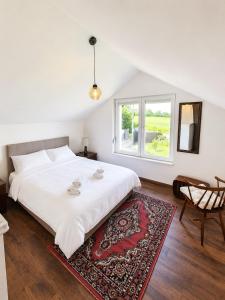 a bedroom with a large white bed and a window at Vila Dinka in Lipovac