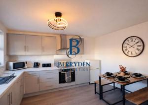 a kitchen with a table and a clock on the wall at Aalesund stay in Peterhead