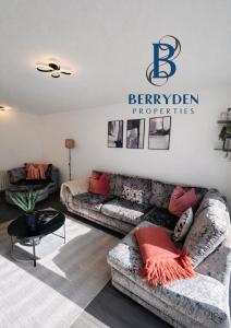 a living room with two couches and a sign at Aalesund stay in Peterhead +5 photos
