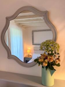 a vase of flowers on a table in front of a mirror at Casa Mirabel Laurel in Fene