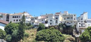 a group of white buildings on a hill with trees at Marbella Views in Ojén
