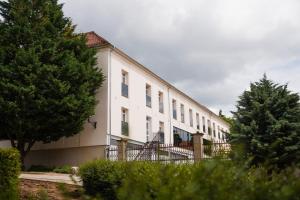a large white building with a fence and trees at Littke Pezsgőház in Pécs +24 photos