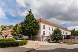 a white building with a tree in front of it at Littke Pezsgőház in Pécs