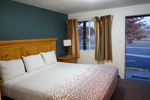 a bedroom with a bed and a large window at Juniper Motel Madras in Madras +4 photos
