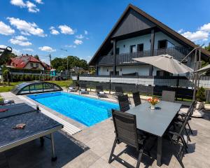 a patio with a table and chairs next to a pool at Luna Et Sol Apartments in Rząska